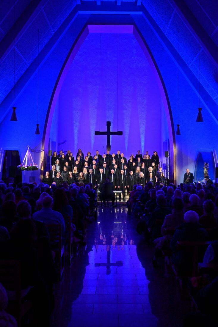 Blick durch den Mittelgang von St. Thomas Morus auf den Chor im blauen Licht