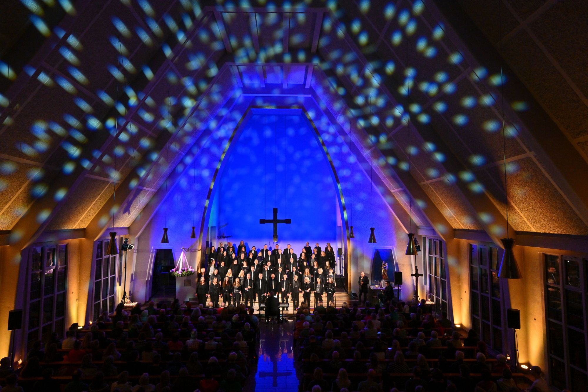 Die Abendsterne singen in der blau erleuchteten Kirche St. Thomas Morus, an der Decke Lichtpunkte wie Sterne